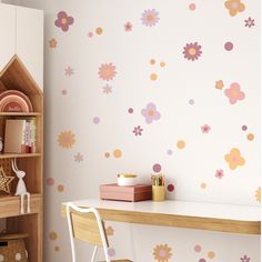 a room with flowers painted on the wall and a wooden desk in front of it