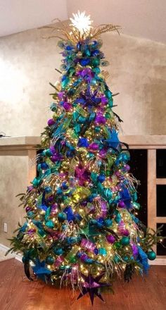 a brightly colored christmas tree in the middle of a living room with lights on it