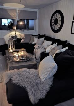 a living room filled with black couches and pillows