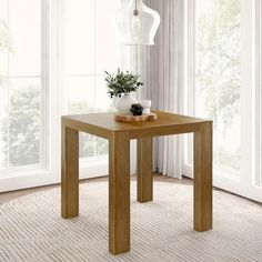 a wooden table sitting on top of a carpeted floor next to a white light fixture