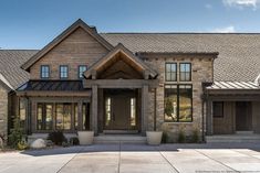 a large stone house with lots of windows on it's front porch and entry way