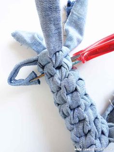 a pair of scissors are being used to tie the ends of two pieces of fabric