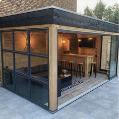 a small wooden building with glass doors and windows