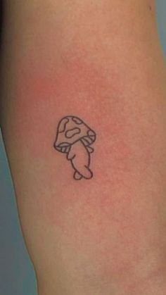 a small mushroom tattoo on the leg