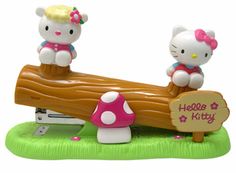 two hello kitty figurines sitting on a log with a sign that says hello kitty