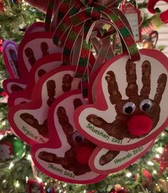 three handprinted christmas ornaments hanging from a tree