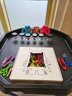 a black table topped with lots of toys and crafting supplies on top of it