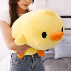 a woman holding a yellow stuffed animal in her hands