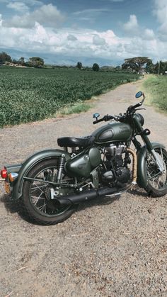 a motorcycle parked on the side of a dirt road