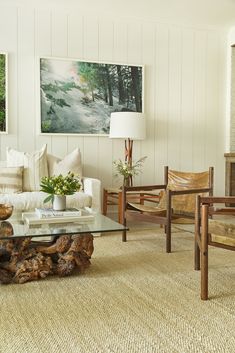 a living room filled with furniture and a painting on the wall above it's fireplace