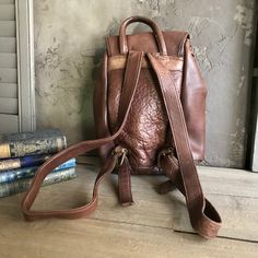 "Vintage Chestnut Brown Leather Backpack 1980s by Robert Cheau Leather drawstring top, one front pocket with strap & buckle closure, roomy interior with one interior zipper pocket, solid brass hardware. Marked Robert Cheau under front flap, made in USA. High quality made. Thick & wide adjustable leather straps. Beautiful full grain leather. Great color and patina. Excellent quality handcrafted. Measures; 12.5\" height, 9.5\" length, approx. 4\" depth, this is a fairly heavy bag, as the l Vintage Travel Backpack With Adjustable Strap, Vintage Brown Leather Backpack For Everyday, Vintage Leather Backpack With Adjustable Strap For School, Vintage Brown Backpack With Leather Lining, Vintage Brown Leather Satchel Backpack, Brown Vintage Backpack With Leather Lining, Vintage Leather Backpack For Daily Use, Vintage Satchel Backpack For Daily Use, Retro Brown Backpack For Everyday Use