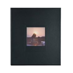 a black frame with a woman sitting on a boat in the water at sunset or sunrise