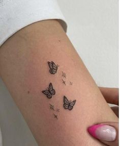 a woman's arm with three small butterflies on the left side of her body