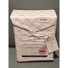 the packaging is wrapped in white paper with pink bows on it and has a tag that says king