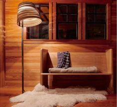 a wooden bench sitting next to a lamp in a room