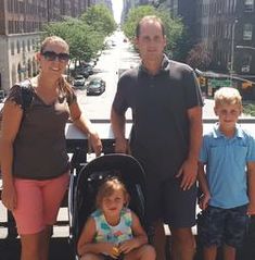 three people standing next to each other with a baby in a stroller