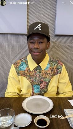 a man sitting at a table in front of a white plate and cup of coffee