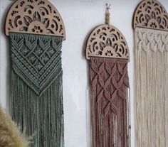 three decorative wall hangings with tassels attached to the side of each one