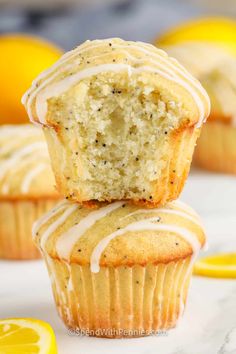 two lemon muffins stacked on top of each other with one bite taken out