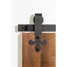 an iron and wood door handle is mounted on the side of a wooden door with black hardware