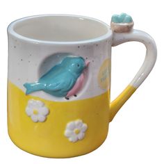 a yellow and white mug with a blue bird on it