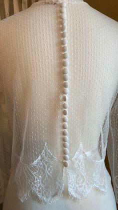 Beautiful off white/pale ivory pointelle topper. Trimmed with cotton embroidered lace at hemline & sleeves. 25 covered buttons enclose the back with button loops. Bust 34/35 Shoulder to shoulder across back 16 Sleeve length (under seam) 16 Biceps 11 Length from shoulder 17 **all fabrics & trims upcycled from other wedding apparel💚 **One of a kind design💕 (fabric swatch available) Feminine White Scalloped Lace, Feminine Wedding Gown With Lace Trim, Feminine Scalloped Lace For Wedding, White Tulle Lace Dress With Lace Back, White Scalloped Lace Dress For Wedding Night, Feminine White Lace Gown, Feminine Wedding Lace With Lace Bodice, Feminine Lace Bodice For Wedding, Elegant Tulle Wedding Dress With Lace Sleeves