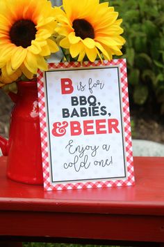 sunflowers in a red watering can with a sign that says bbq babies and beer