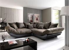 a living room with a large sectional couch and coffee table in it's center