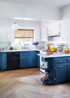 a kitchen with blue cabinets and white counter tops