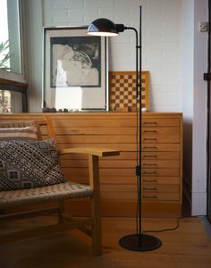 a floor lamp sitting on top of a hard wood floor next to a wooden chair