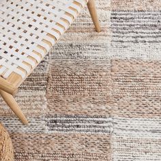 an area rug with different colors and patterns on the floor, including one white chair