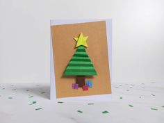 a card with a christmas tree cut out of paper