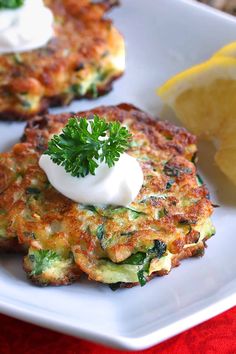 some food is on a white plate with lemon wedges and a green garnish