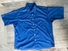 "This deep blue, genuine 1970s vintage, short sleeve, butterfly collared shirt is in excellent vintage condition. SIZE: Pit to Pit: 25\" Collar to hem: 31\" Sleeves: 11\" The tag does not have a size. Check the measurements. I would say it fits like a roomy XL The male mannequin would be 5'10\" 170 lbs. ITEM 125" Vintage Solid Color Short Sleeve Shirt, Retro Blue Collared Short Sleeve Shirt, Blue Retro Collared Short Sleeve Shirt, Vintage Blue Collared Short Sleeve Shirt, Retro Blue Short Sleeve Shirt, Formal Short Sleeve Blue Tops, Formal Blue Short Sleeve Top, Vintage Blue Cotton Short Sleeve Shirt, Classic Fitted Blue Short Sleeve Shirt