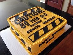 a cake that is sitting on top of a table with the words caution 50 years old