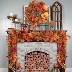 a fireplace decorated with fall leaves and pumpkins