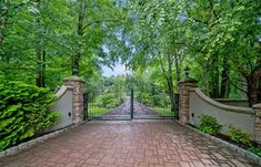 a gated driveway leading into a lush green park