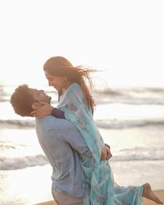 a man carrying a woman on his back at the beach