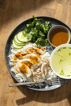 a plate filled with rice, chicken and cucumbers next to a bowl of soup