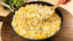 a skillet filled with macaroni and cheese on top of a wooden cutting board