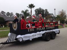 people dressed as santa clause riding on the back of a float