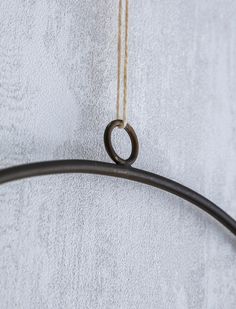 a metal hook hanging from the side of a towel rack on a white towel covered wall