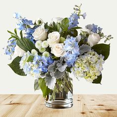 a glass vase filled with blue and white flowers