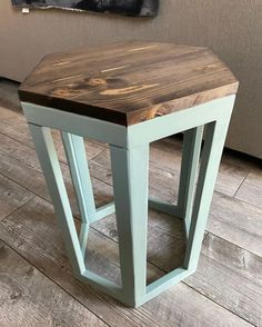 a small wooden table sitting on top of a hard wood floor next to a couch