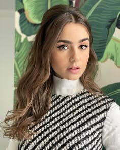 a woman with long hair wearing a black and white sweater