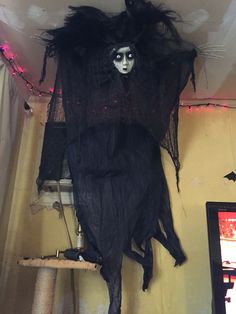 a creepy doll hanging from the ceiling in a room decorated with lights and stringing