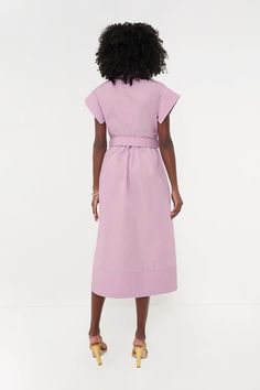 Elegant in its simplicity, the structured and ultra-ladylike Lilac Chloe Dress is done in a textured cotton-blend fabric that is sure to turn heads for its design details. The moire pattern throughout and trapunto stitching on the sleeves, placket, and hemline complete this midi moment, making it feel extra special with minimal effort. Pair with heels or flats, sunnies or statement earrings, for day or night, and rest assured that you look fabulous! Spread collar Short wing sleeves Button front placket Optional adjustable fabric belt with buckle closure (included) Side seam pockets Trapunto stitching on sleeves, placket, and hemline Midi length Moire fabric Material: 80% Polyester, 20% Cotton Care: Dry clean only Cotton Fitted Maxi Dress For Work, Fitted Cotton Maxi Dress For Work, Modern Fitted Cotton Dresses, Modern Knee-length Cotton Dress, Feminine Cotton Dresses For Work, Structured Spring Workwear Dresses, Fitted Feminine Cotton Shirt Dress, Structured Short Sleeve Spring Dress, Structured Short Sleeve Dress For Spring