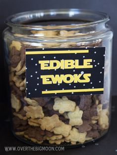 a glass jar filled with edible ewoks on top of a black tablecloth