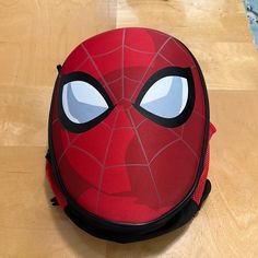 a spiderman backpack sitting on top of a wooden floor