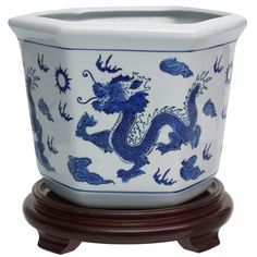 a blue and white dragon planter on a wooden stand